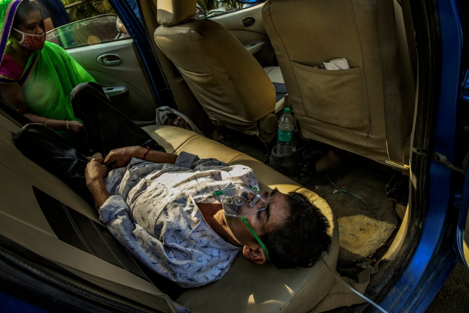 A man lying in his car as he gets oxygen