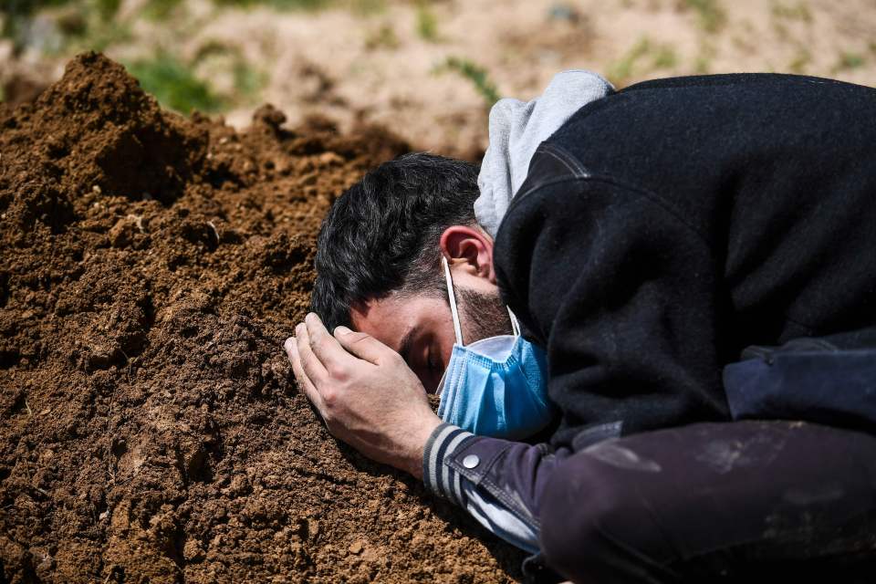 Umar Farooq mourns at the grave of his mother, who died of Covid