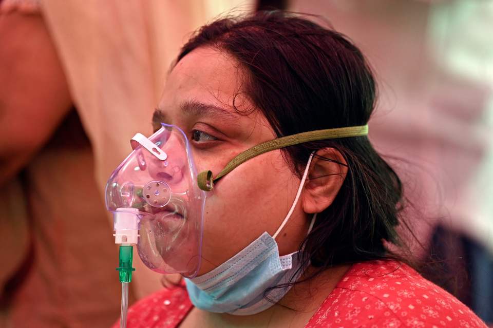 A Covid patient breathes with the help of oxygen