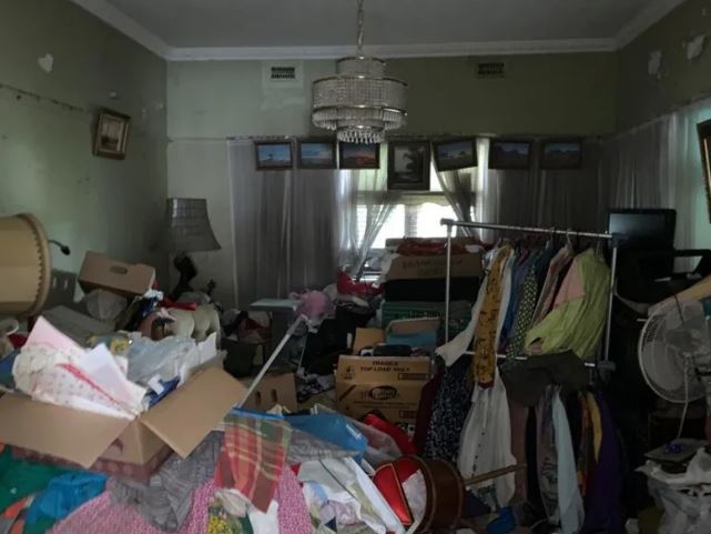 Clothes rails and cardboard boxes fill one room