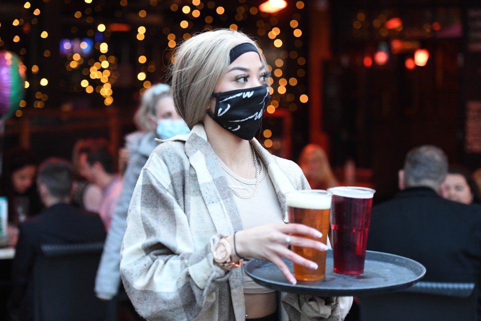 A waitress carries beers to outdoor tables