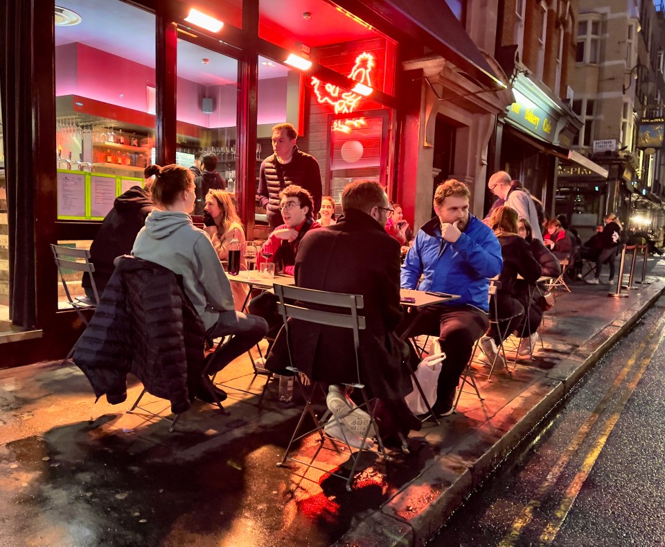 Restaurant patrons wait for their meals outside a food spot in Soho