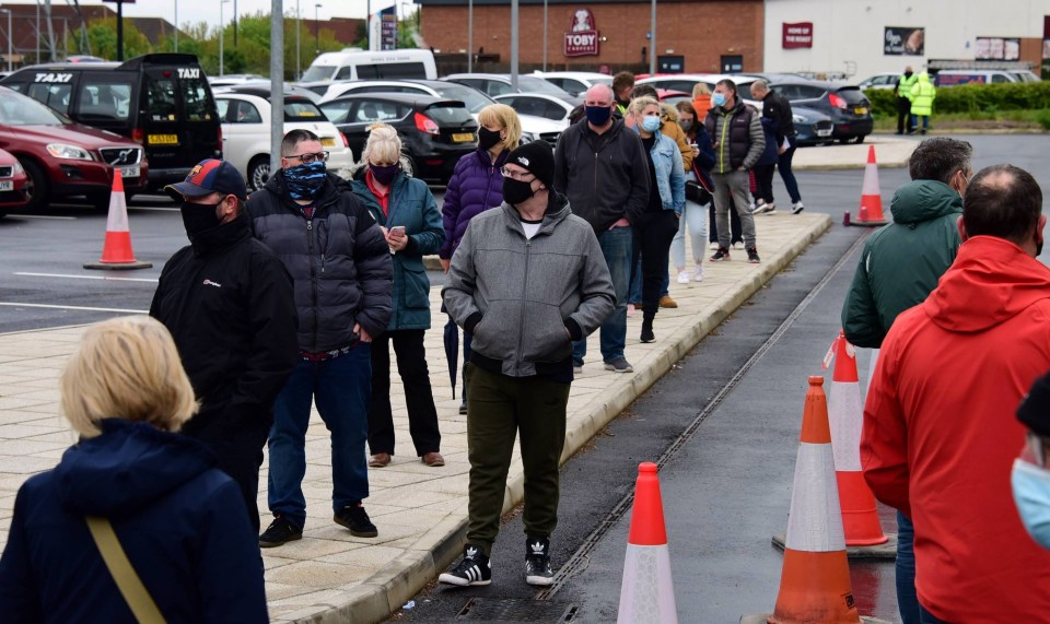 A queue of people wait outside the Covid mobile testing station in Shiremoor, North Tyneside