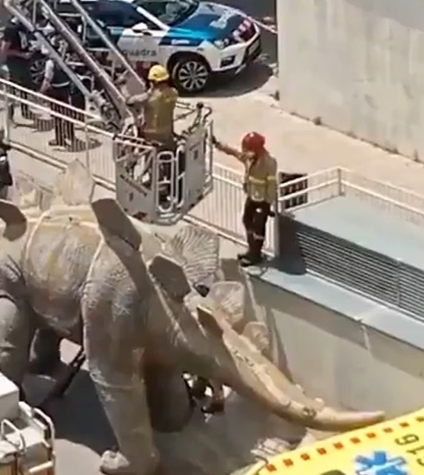 The man's body being retrieved from inside the dinosaur