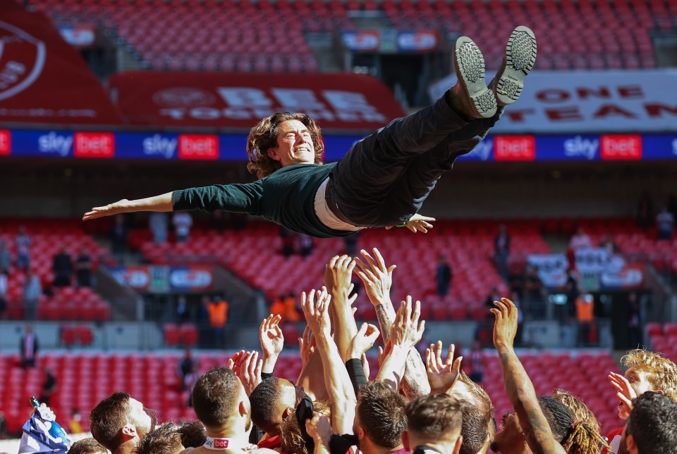 Jubilant Brentford players give Thomas Frank the bumps after winning promotion