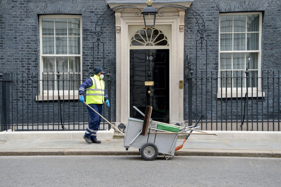 A cleaner sweeps outside No10 Downing Street