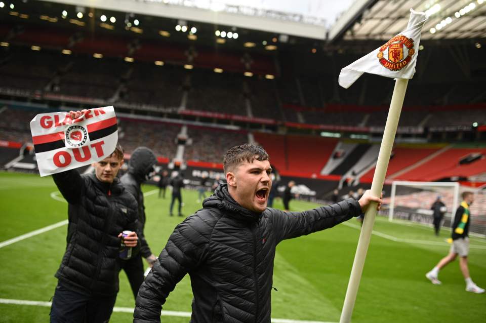 A fan grabs a corner flag from the Old Trafford pitch