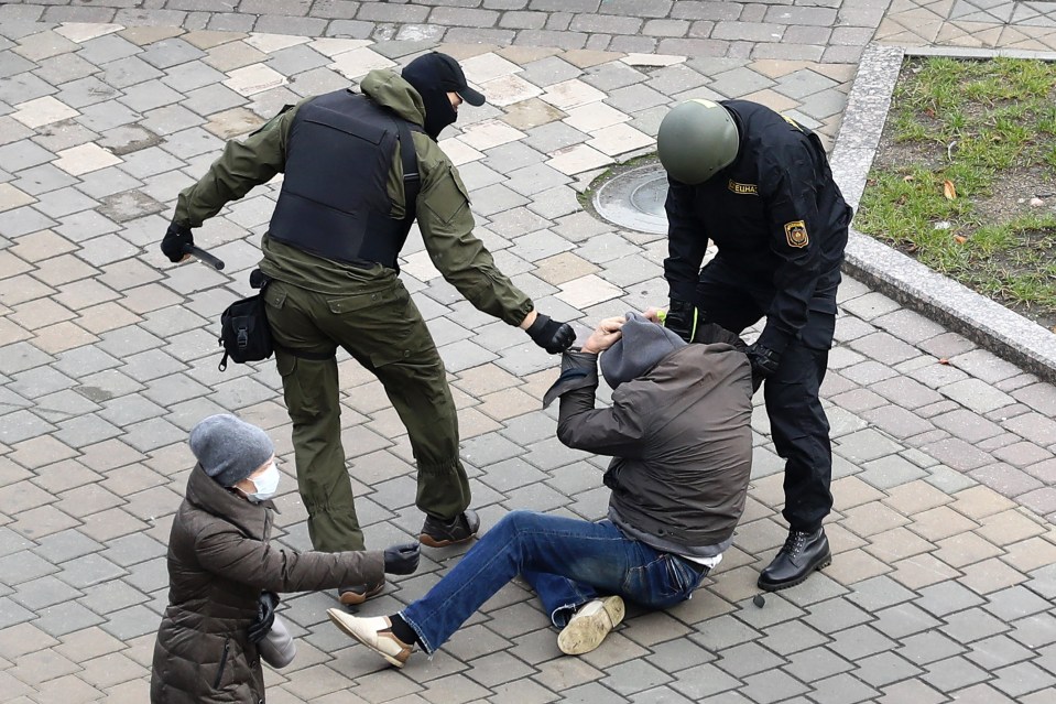 Police officers detain a man in Minsk during a demonstration against the President