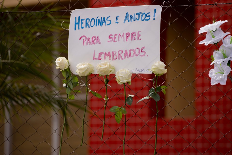 A tribute with five white roses reads 'Heroes and angels, forever remembered'