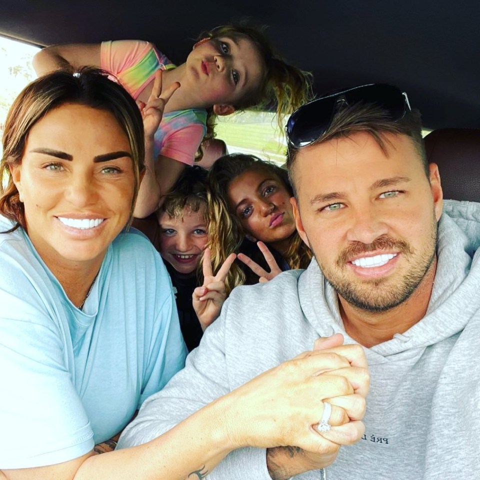 Katie and Carl hand in hand with her children at a safari park at the weekend