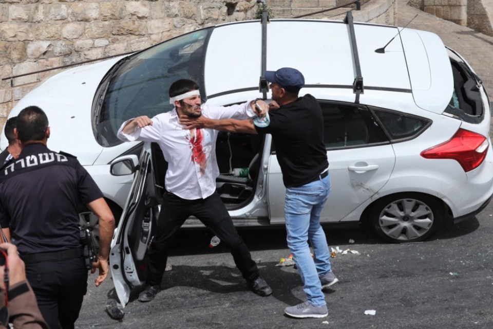 A man scuffles with a wounded Orthodox Jewish man who crashed his car