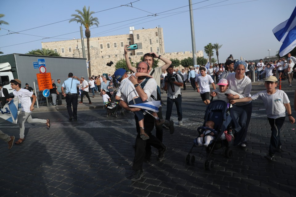 Israelis run to shelters as air attack sirens goes off during a Jerusalem Day march