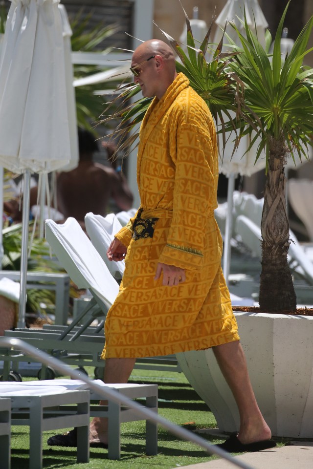 Tyson wore a bright yellow Versace robe as he left the pool