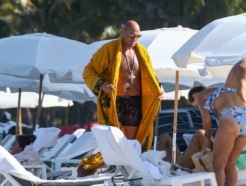 He put on his Versace robe to leave the beach