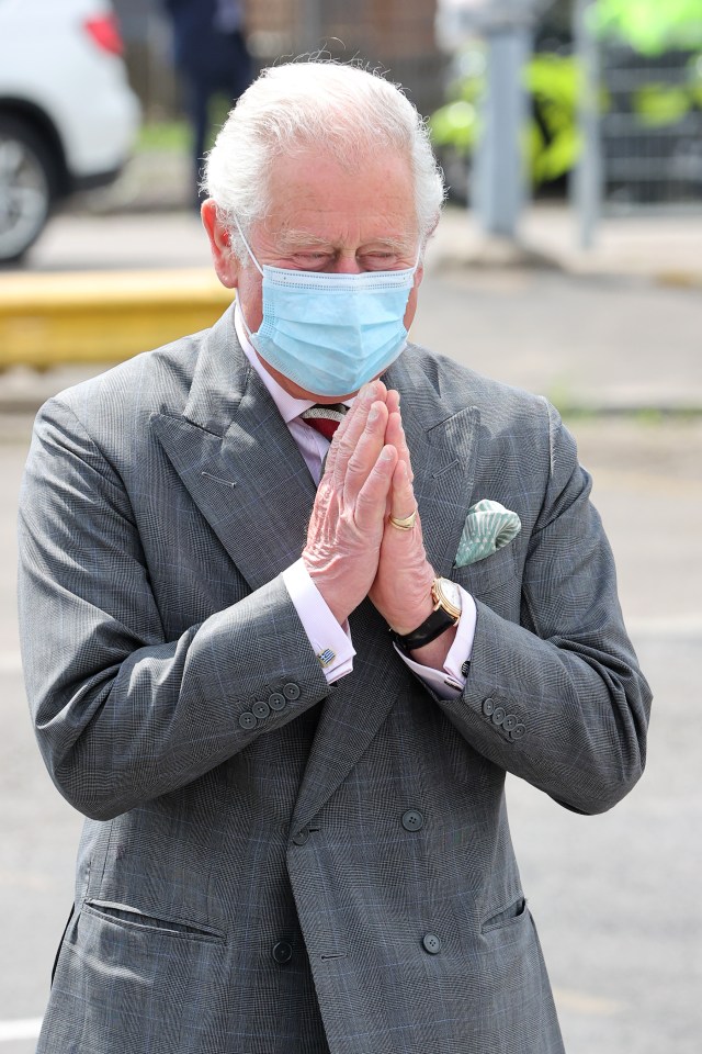 Charles appeared to smile from beneath his mask as he gave a Covid friendly greeting