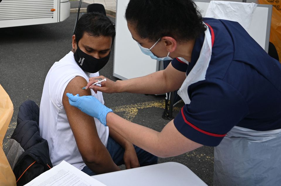 Pictured: A member of the public receives a Covid vaccine at a temporary vaccination centre at the Essa academy in Bolton, Greater Manchester