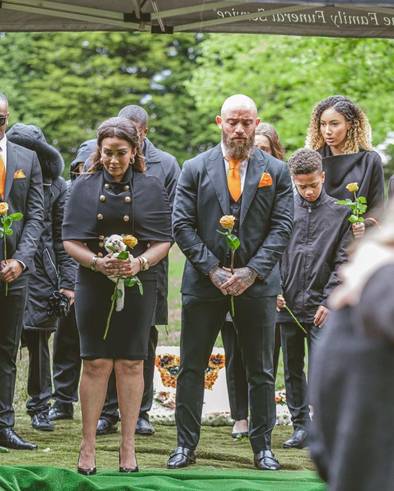 The couple carried orange roses