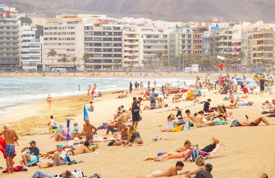 Locals and tourists alike flock to  the city beach in Las Palmas on Gran Canaria, in the Canary Islands