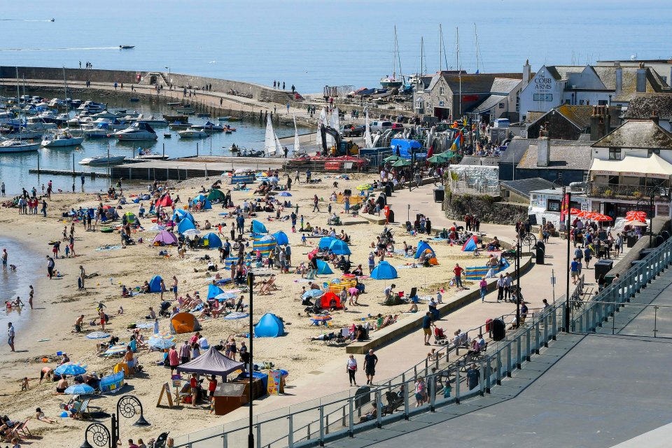 Sunbathers and holidaymakers flock to the seaside resort of Lyme Regis in Dorset