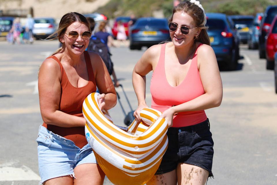 Two pals smile on their way to the beach in Camber Sands