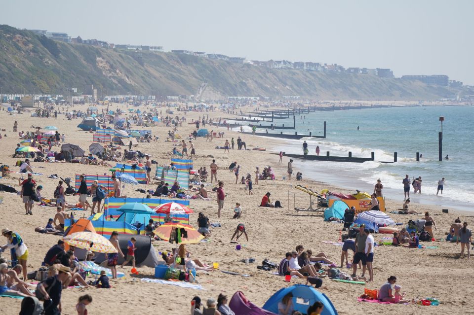 People gather in the good weather at Boscombe beach, Dorset