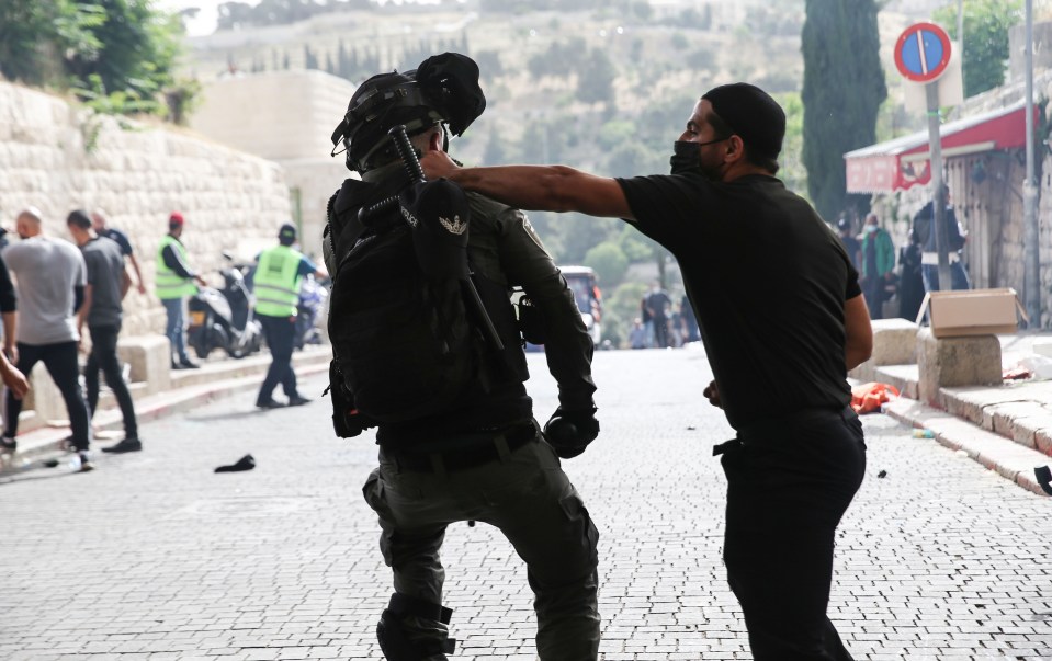 A man clashes with an Israeli cop