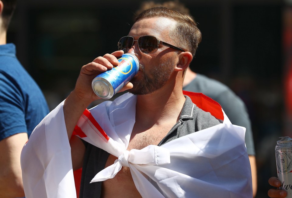 A fan quenches his thirst in the scorching heat