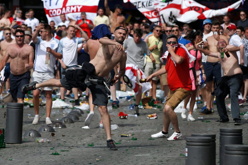 English supporters throw bottles as they clash with riot police at the Old Port of Marseille