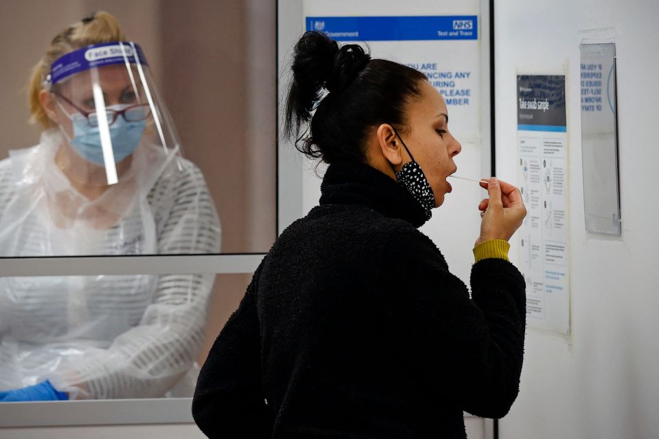 A woman takes a sample at a Covid-19 testing unit in Uxbridge, Hillingdon, west London