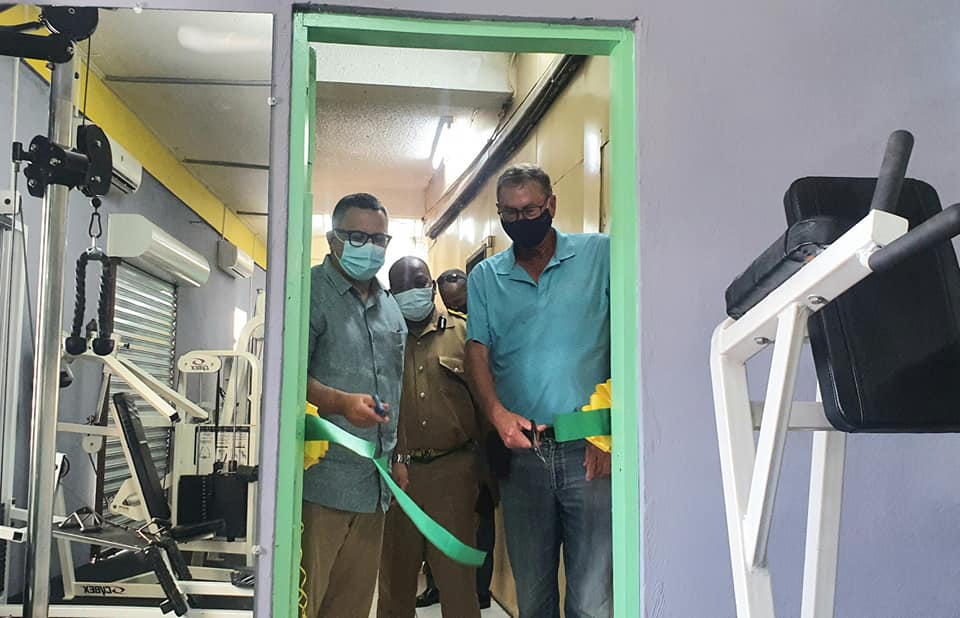 Lord Ashcroft (right) with Lord Kareem Musa, Minister of Home Affairs, and Commissioner of Police Chester Williams cutting the ribbon to a new gym at Belize's main police station