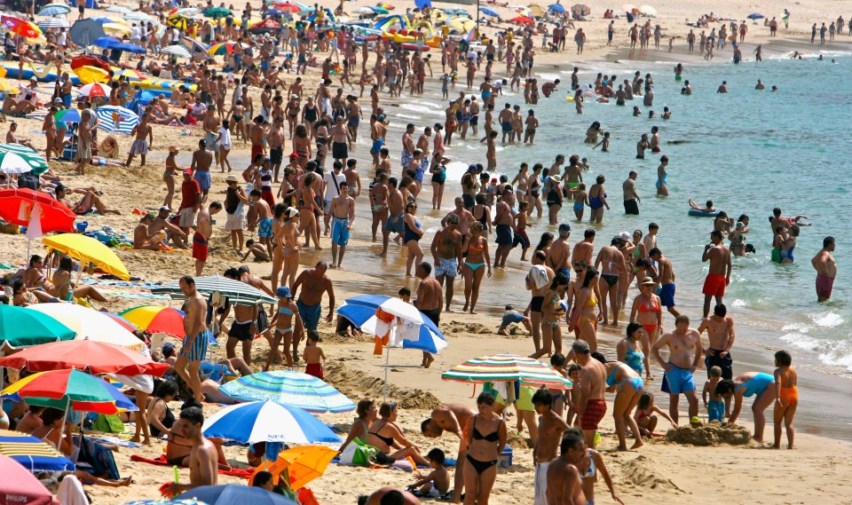 Sunbathers and swimmers at the beach in the Algarve, Portugal