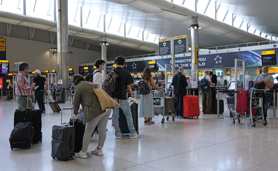 Passengers check in at Heathrow Airport Terminal 2 amid confusion about the latest travel arrangements