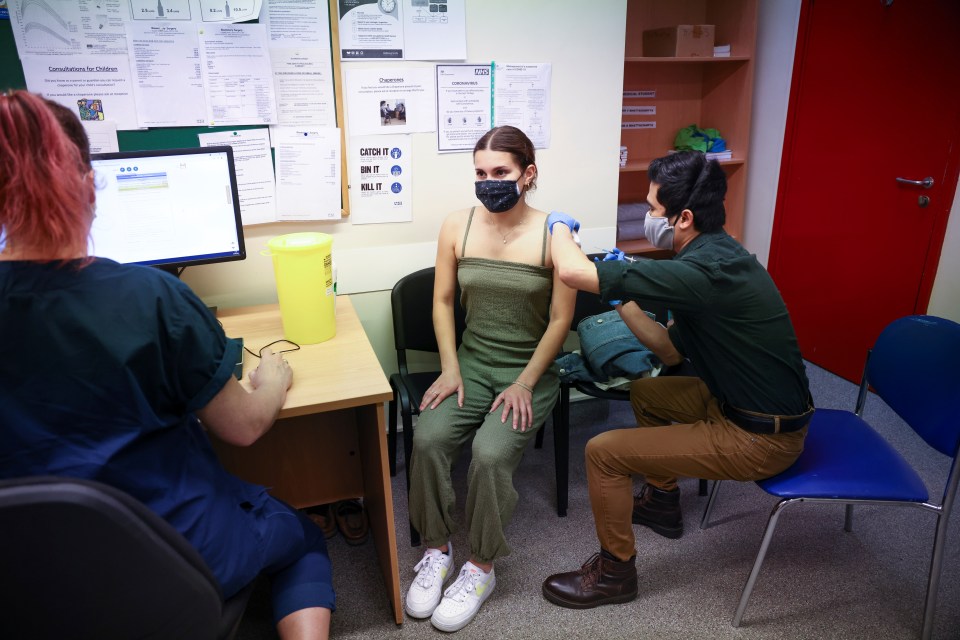 A woman receives a dose of the Pfizer BioNTech vaccine in London