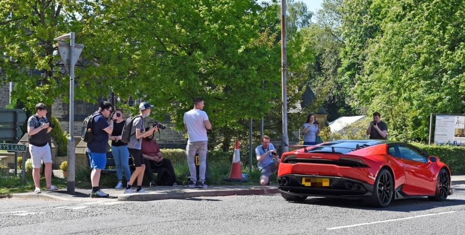 Supercar spotters take photos of a Lamborghini in Alderley Edge