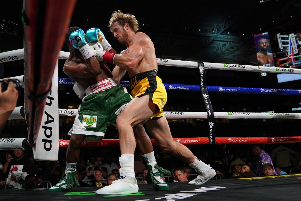 Floyd Mayweather tucks up in the corner as Logan Paul throws a barrage of punches