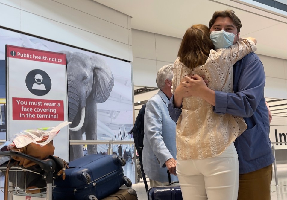 A pair embrace as people jump on the last flights back to Britain before Portugal is taken off the green list