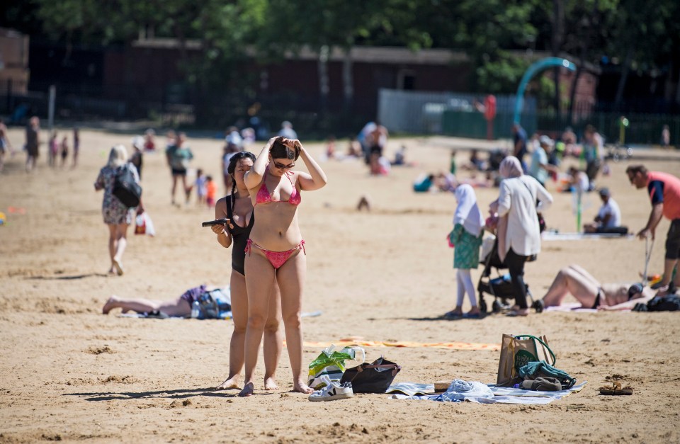 Members of the public relax in the hot weather at Ruislip Lido