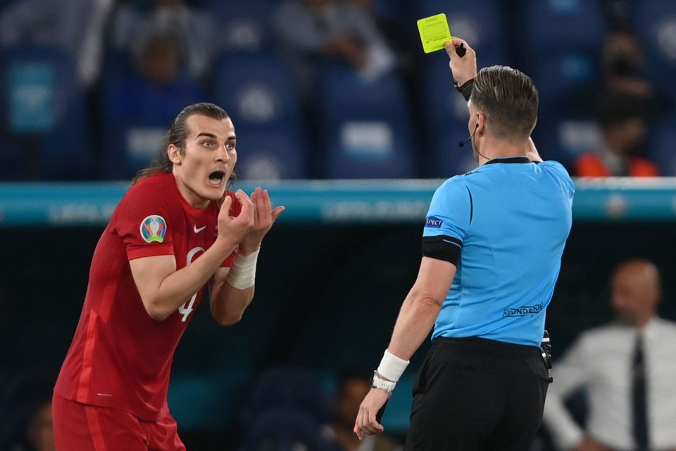 Turkey's Caglar Soyuncu pleads his innocence as he receives a yellow card