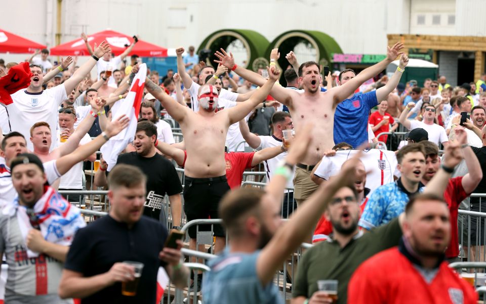 Manchester fans raise their arms as the whistle blows