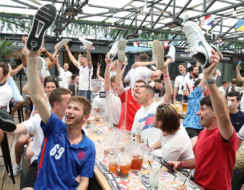 Supporters hold up their shoes at Box Park as the football gets underway