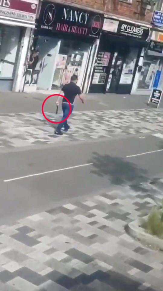 The man was filmed calmly walking down the street with the huge machete