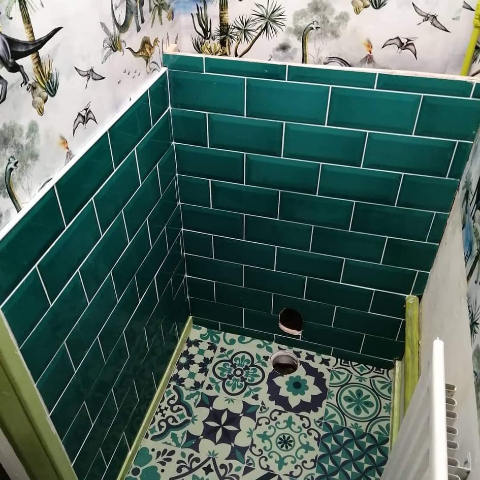 The green tiles and vinyl flooring add to the jungle theme