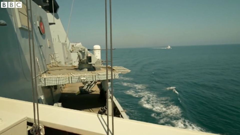 The Russian Coastguard can be seen in the distance (R) shadowing HMS Defender