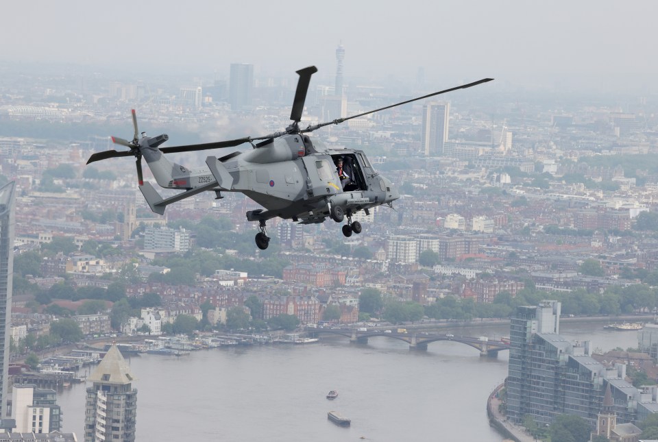 He is pictured flying over London by helicopter after a trip to Aldershot