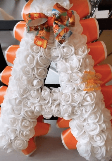 Her name was also spelt out in orange and white flowers with Lion King bows