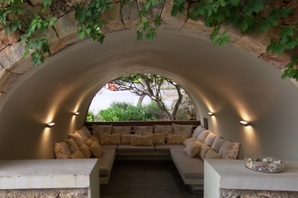 The property features a unique covered seating area under a stone archway