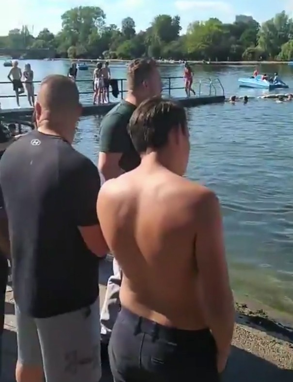 The men stood and watched as the ponies cooled off in the water