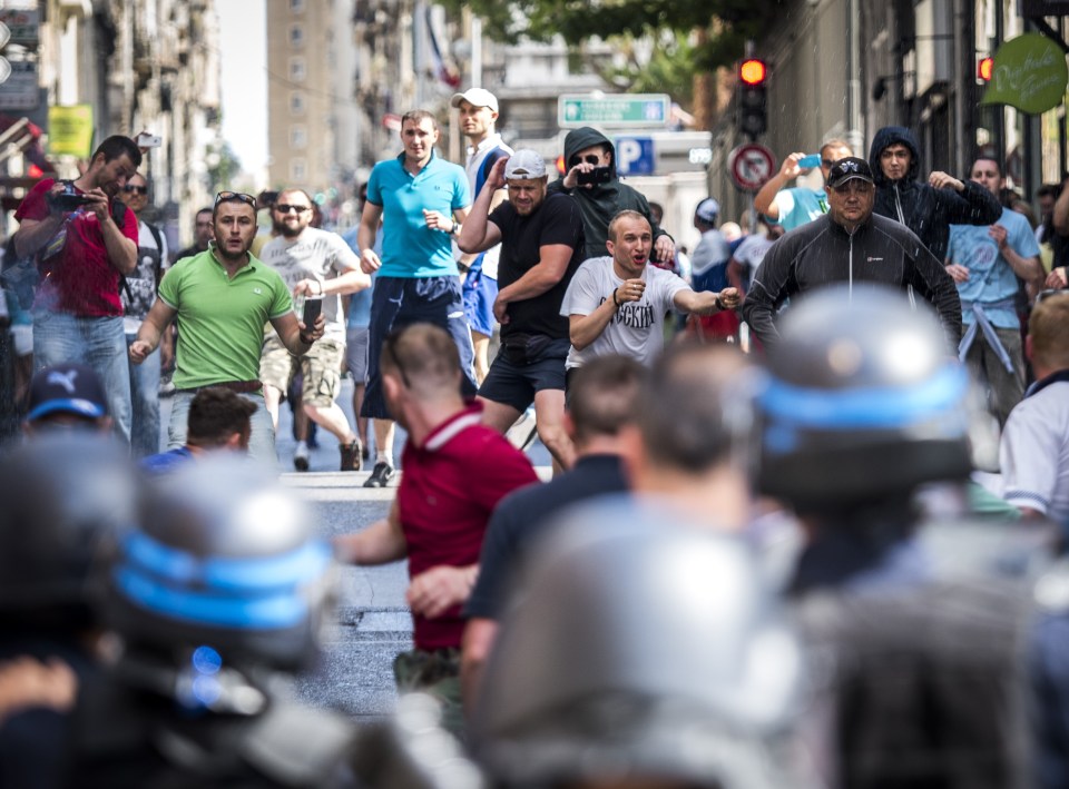 Russian supporters throw glass bottles as they clash with riot police in the French city