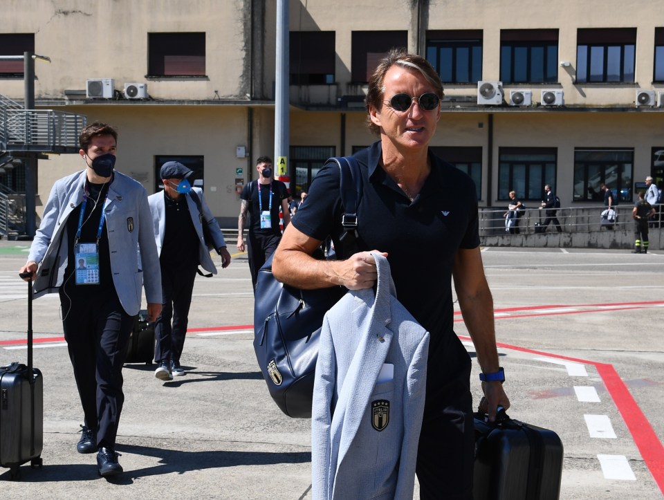 Roberto Mancini leads his side off the aircraft at Luton Airport