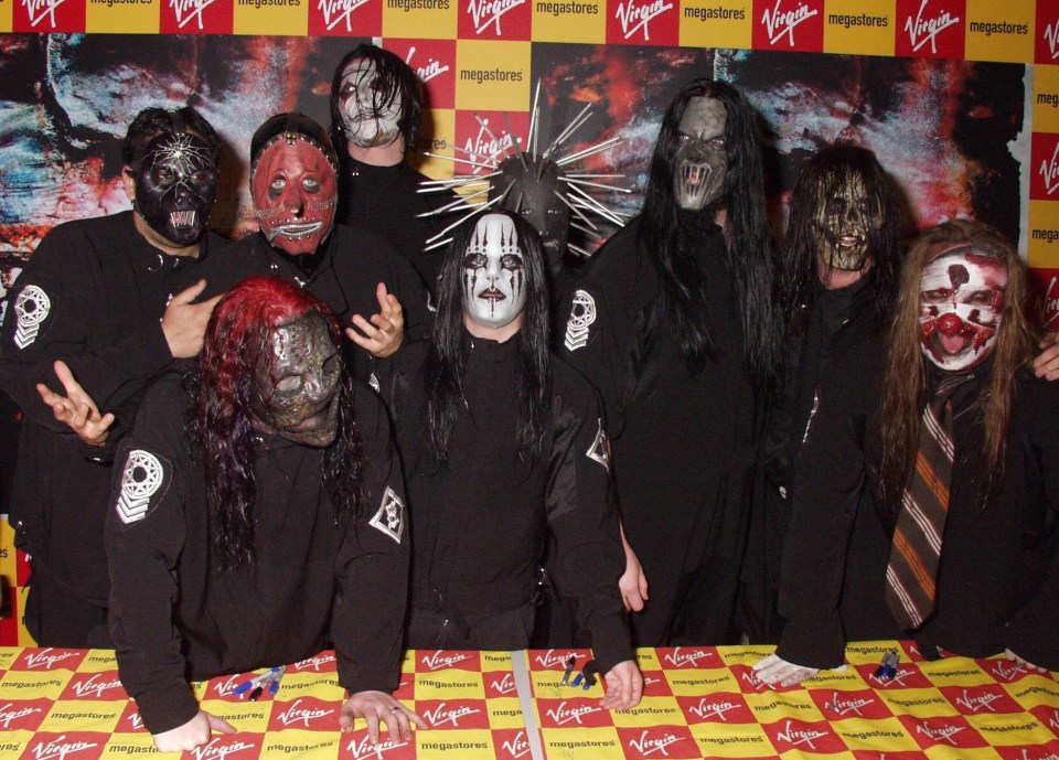 Slipknot featuring Joey Jordison (white mask) and bandmates, including Corey Taylor (bottom left) and Mick Thompson (third from right)